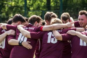 Amateurfußballer im Mannschaftskreis mit verschränkten Armen